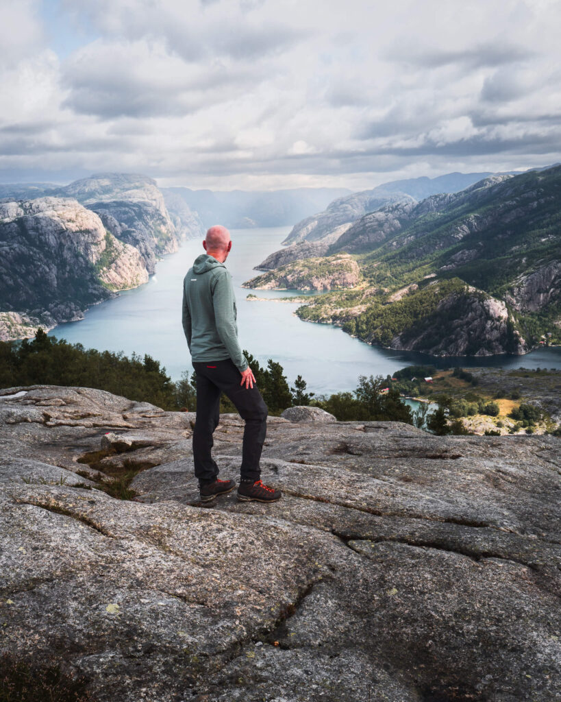 Hiker overlooking the Geirangerfjord from the Queen’s Chair viewpoint in western Norway