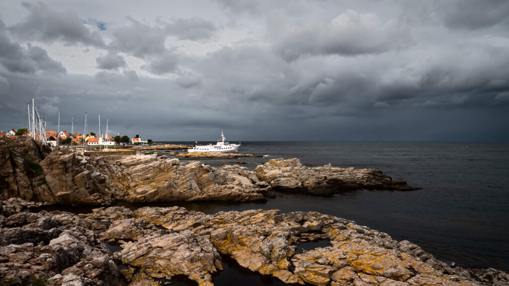Rocky coastline near Gudhjem on Bornholm island in Denmark under a dramatic stormy sky